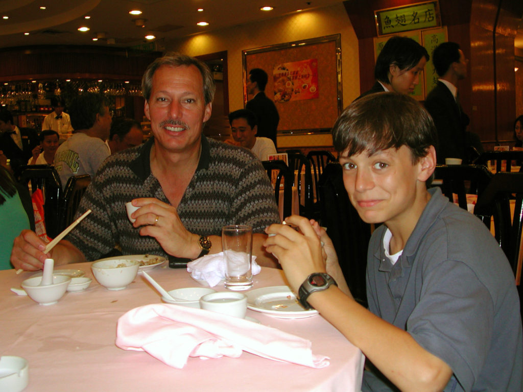 a man and boy eating with chopsticks