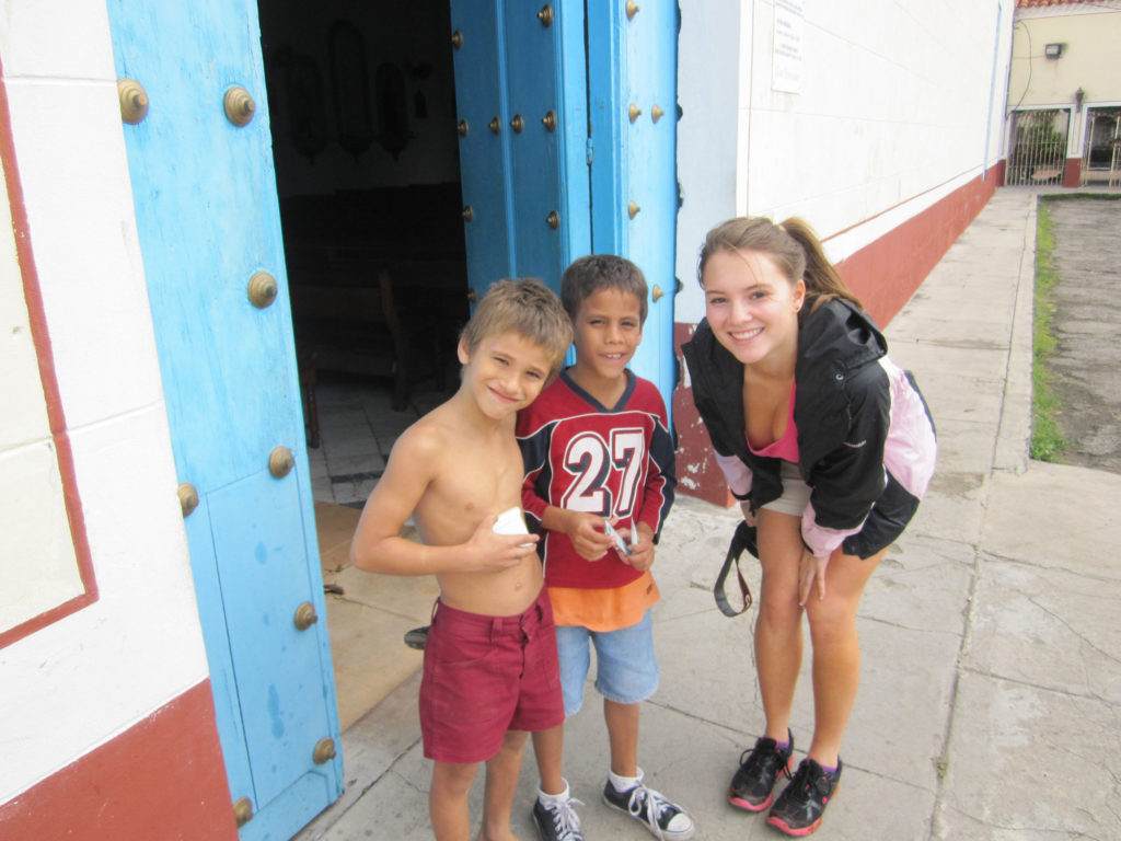 Two kids smiling with Briana in Cuba