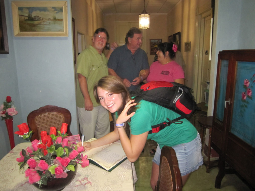 Briana signing the guest book of the Paladar Estela in Cuba
