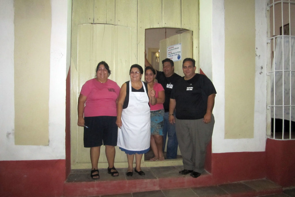 Five adults at the door of their paladar in Cuba