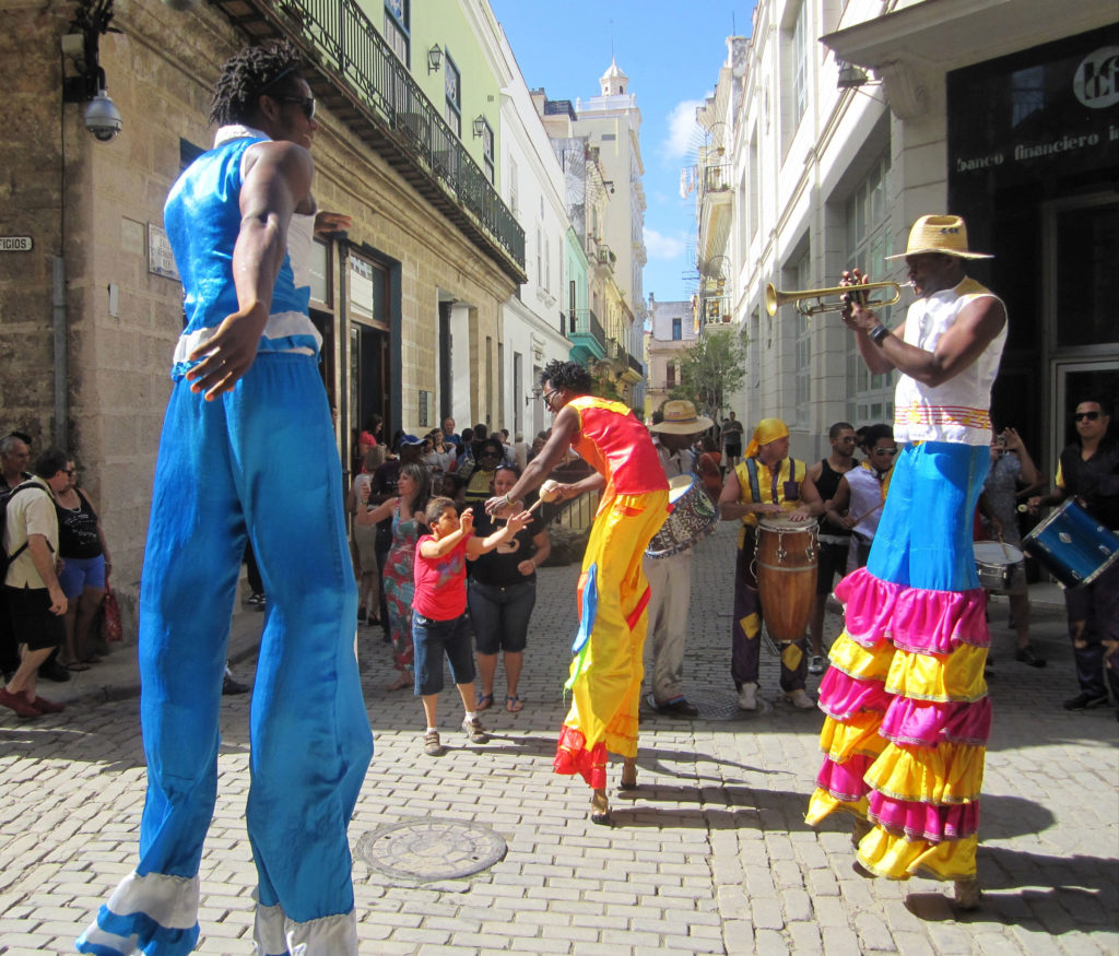 three men on stilts and in costumes on the street