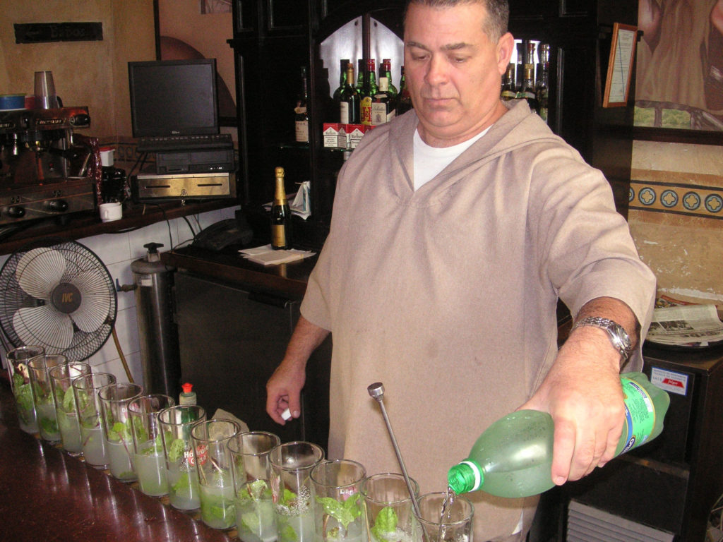 A bartender mass producing mojitos