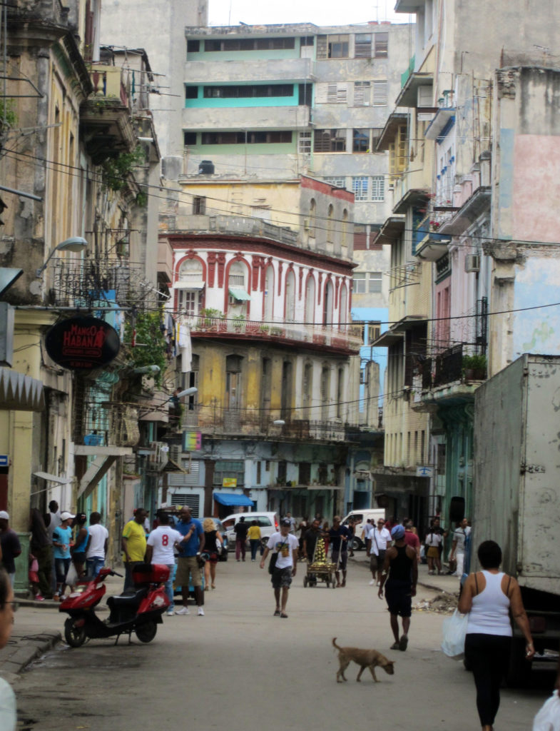 a street scene of old buildings and with lots of people in Old Havana Cuba