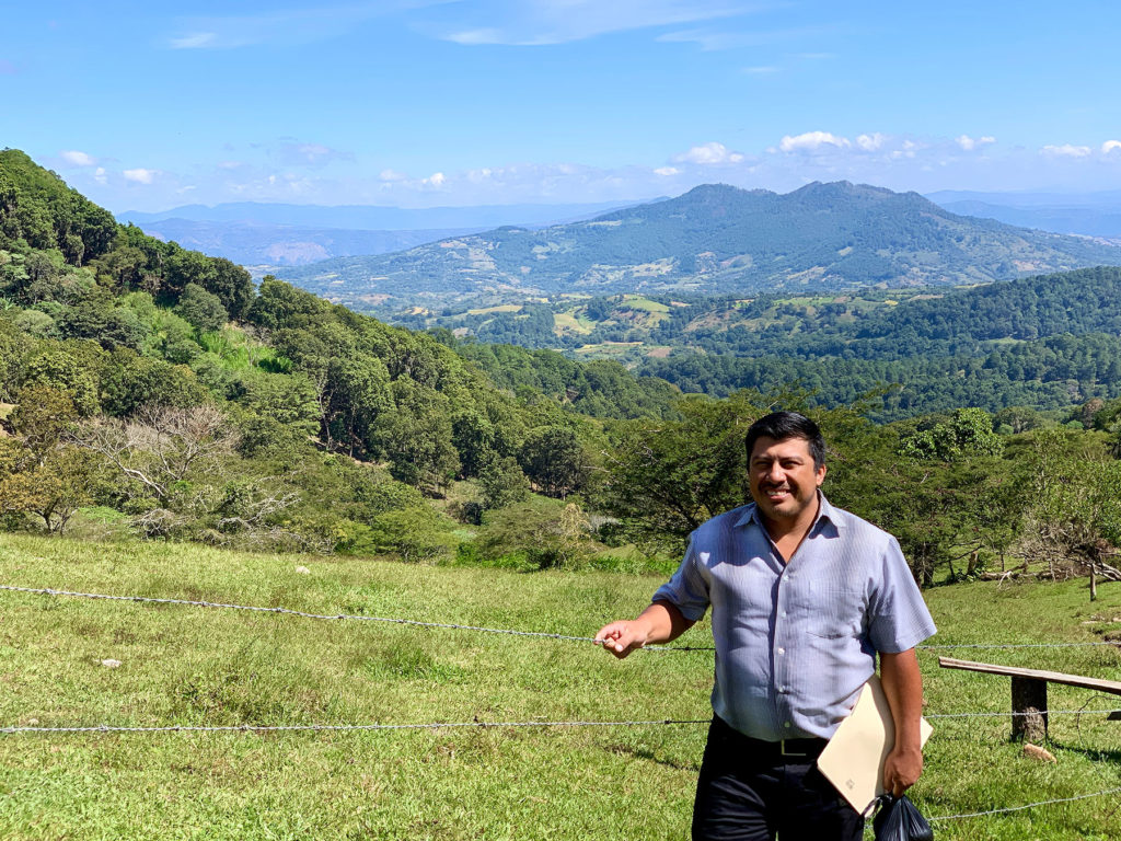 a Latino man standing in front of mountainous Nicaraguan landscape