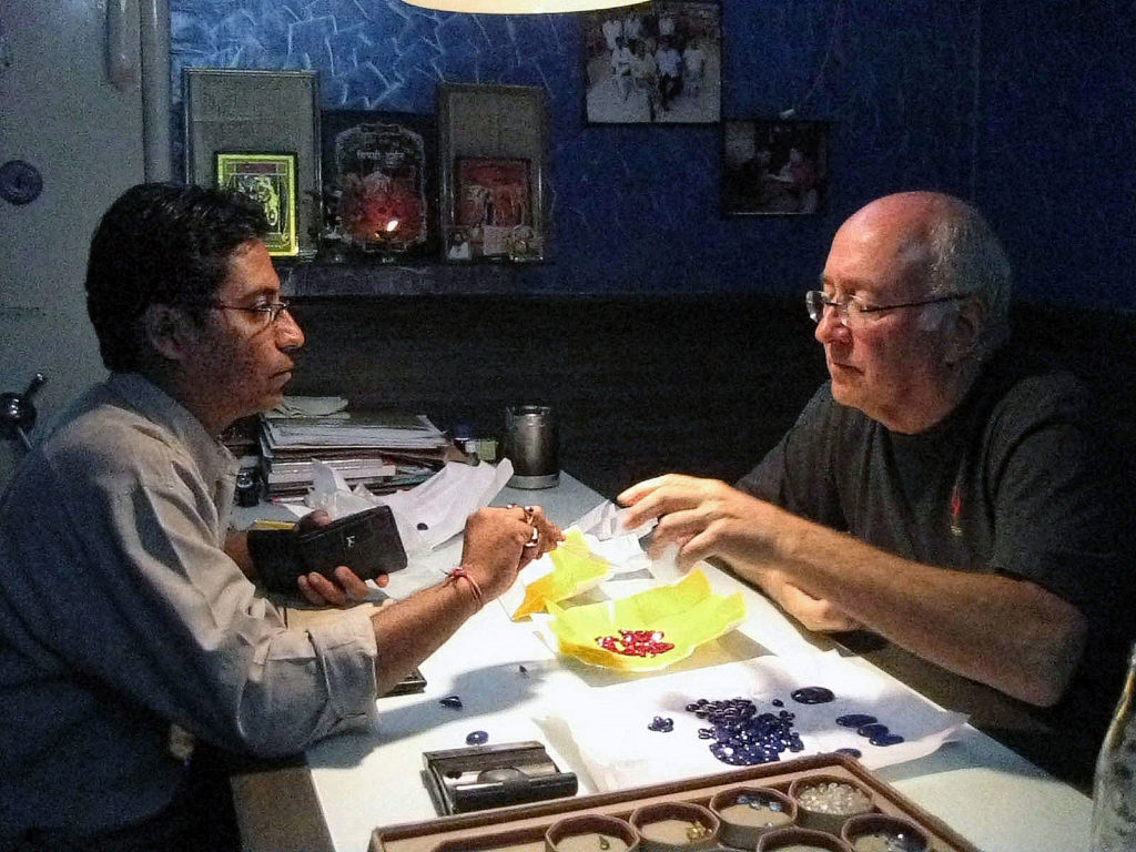 Paul examining jewels with a salesman